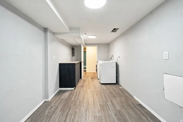 Wood-finish flooring, recessed lighting, built-in cabinetry with a light-colored countertop