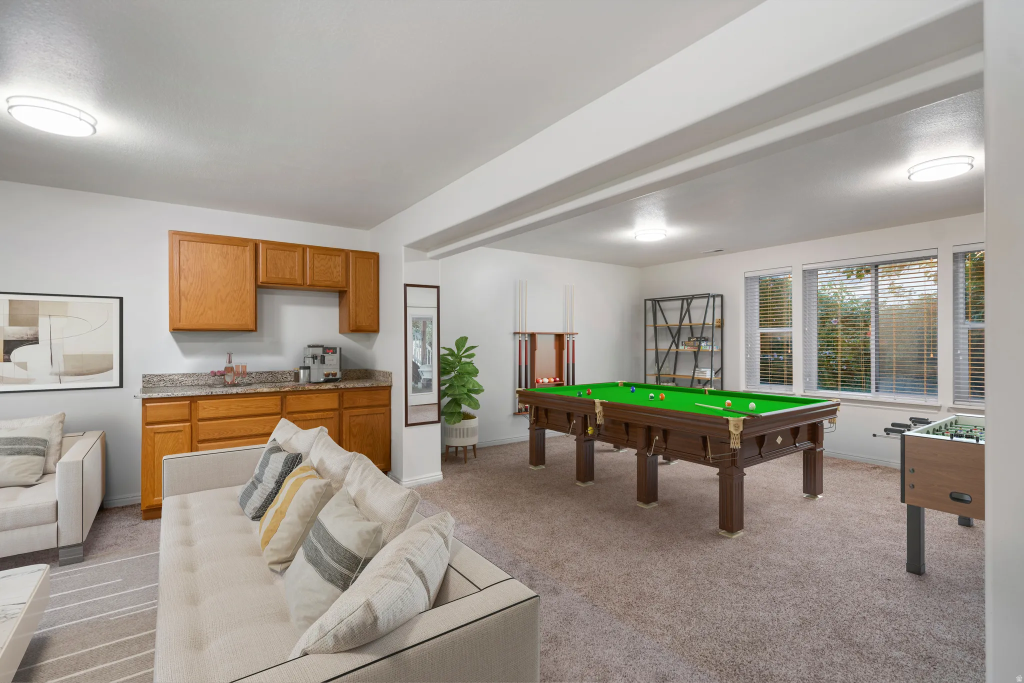 Entertainment area featuring a built-in wet bar with wood cabinetry and a stone-look countertop, recessed lighting, and multiple windows