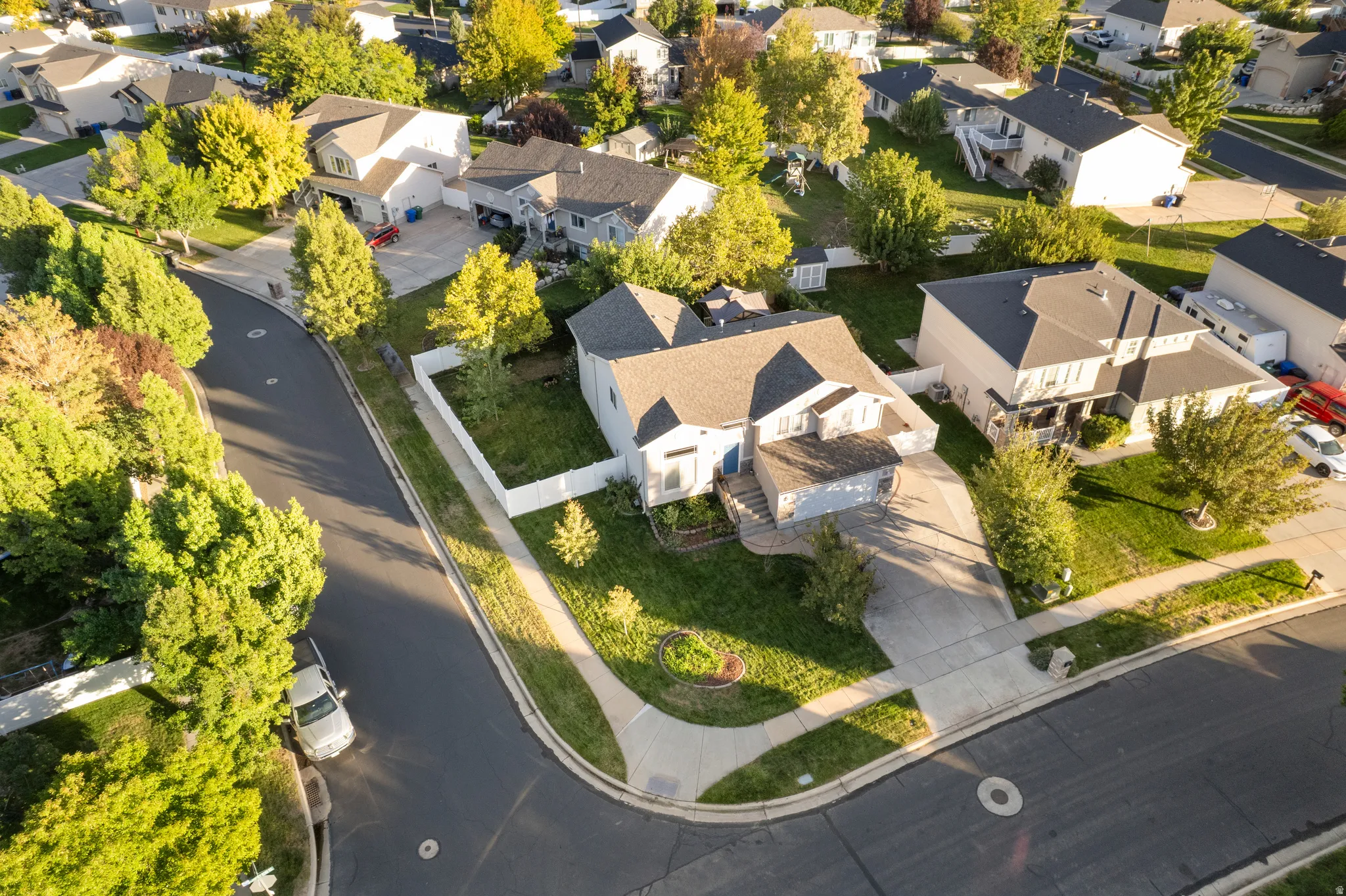 Suburban neighborhood setting with mature trees and paved streets