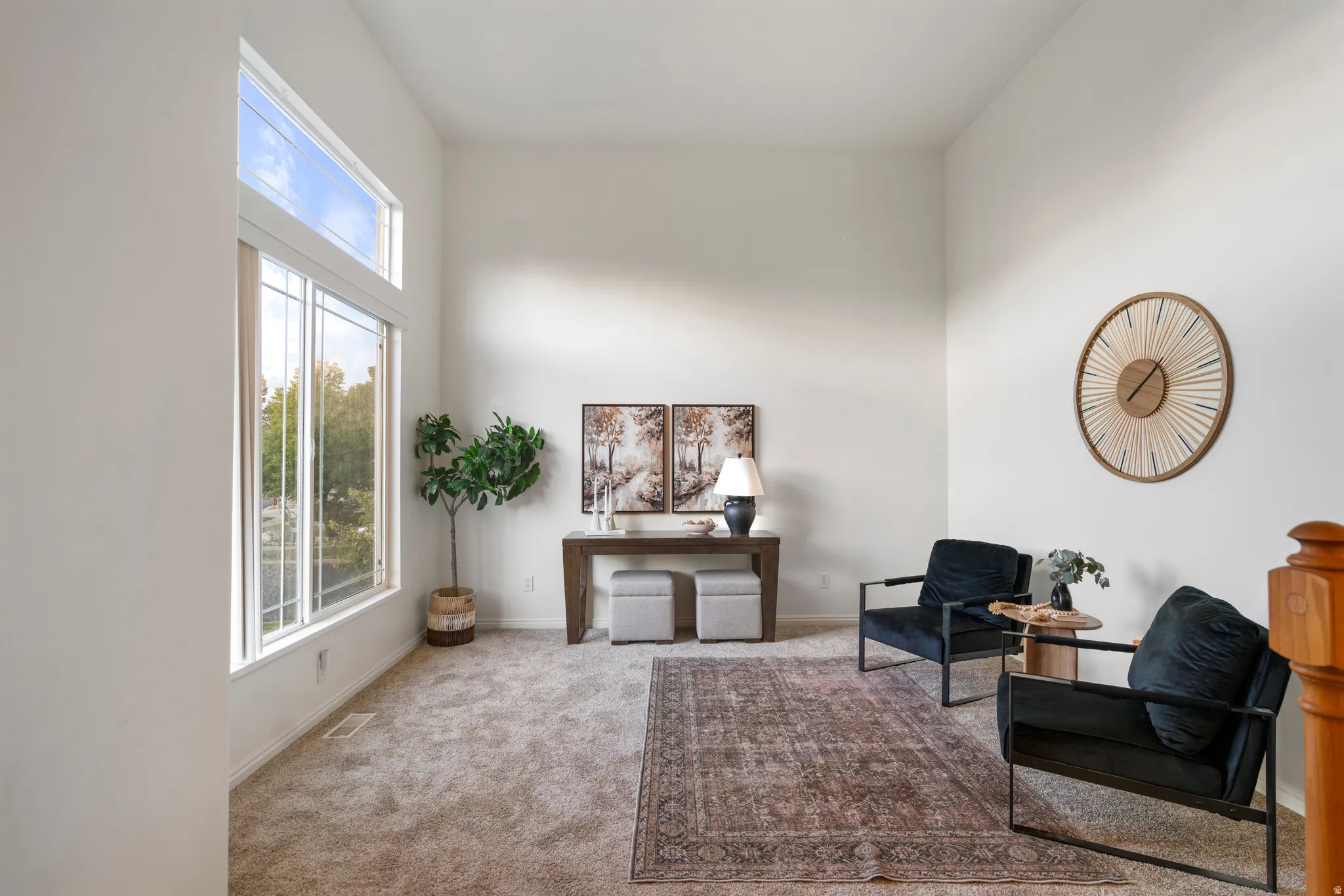 Two-story window, vaulted ceiling, and neutral carpet flooring
