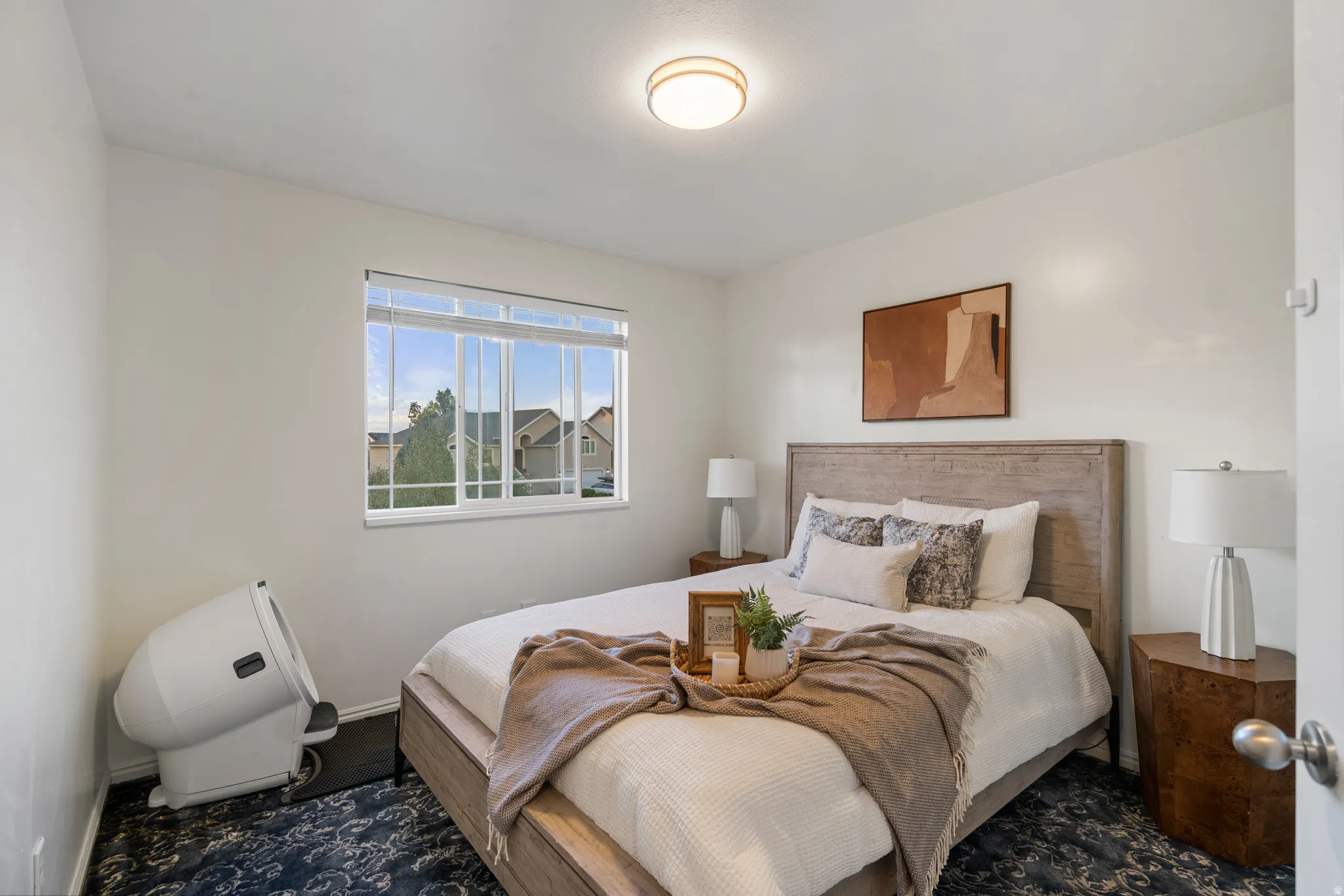 White walls with a single window, a bed with a wooden headboard, and a flush mount ceiling light