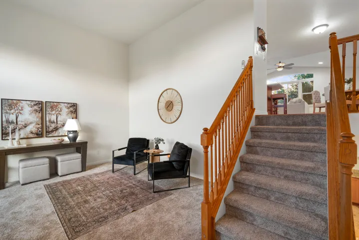 Carpeted staircase with wood banister