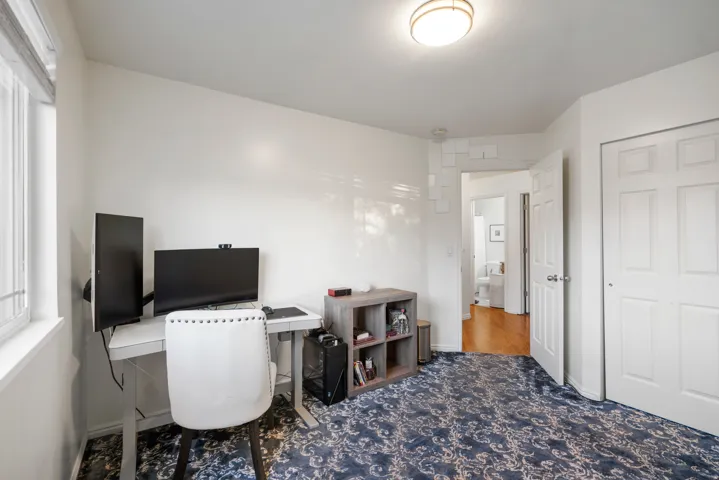 White walls, recessed window, patterned carpet, flush mount ceiling light, and a white paneled door