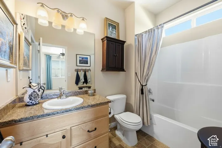 Bathroom featuring a vanity with an integrated sink, a built-in bathtub/shower combination, overhead transom windows, and a wall-mounted medicine cabinet
