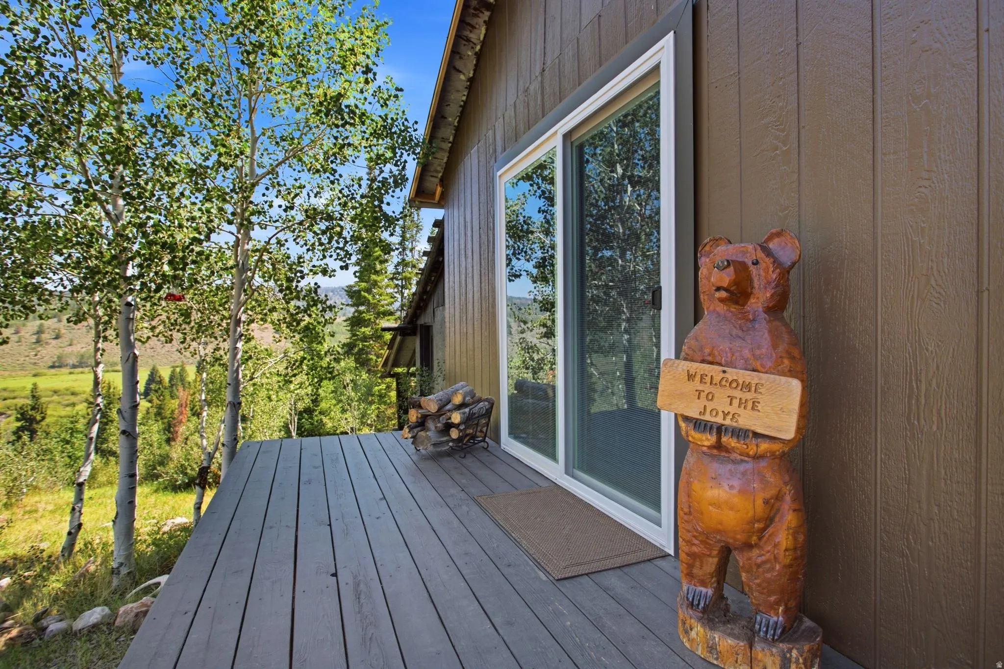 Bunkhouse- Expansive outdoor deck with wood-finish decking, siding exterior, and sliding glass door
