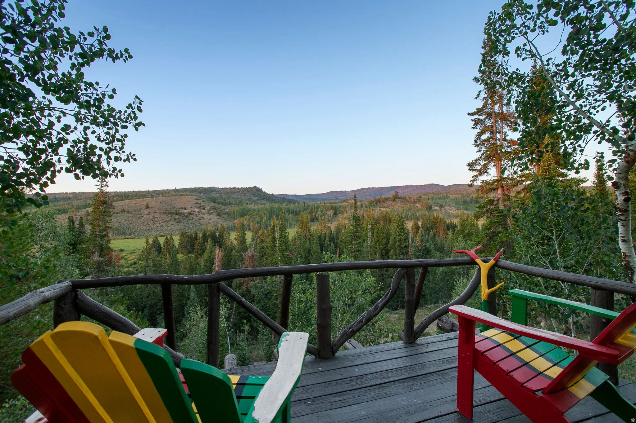 Wood deck with rustic branch railing and expansive natural landscape