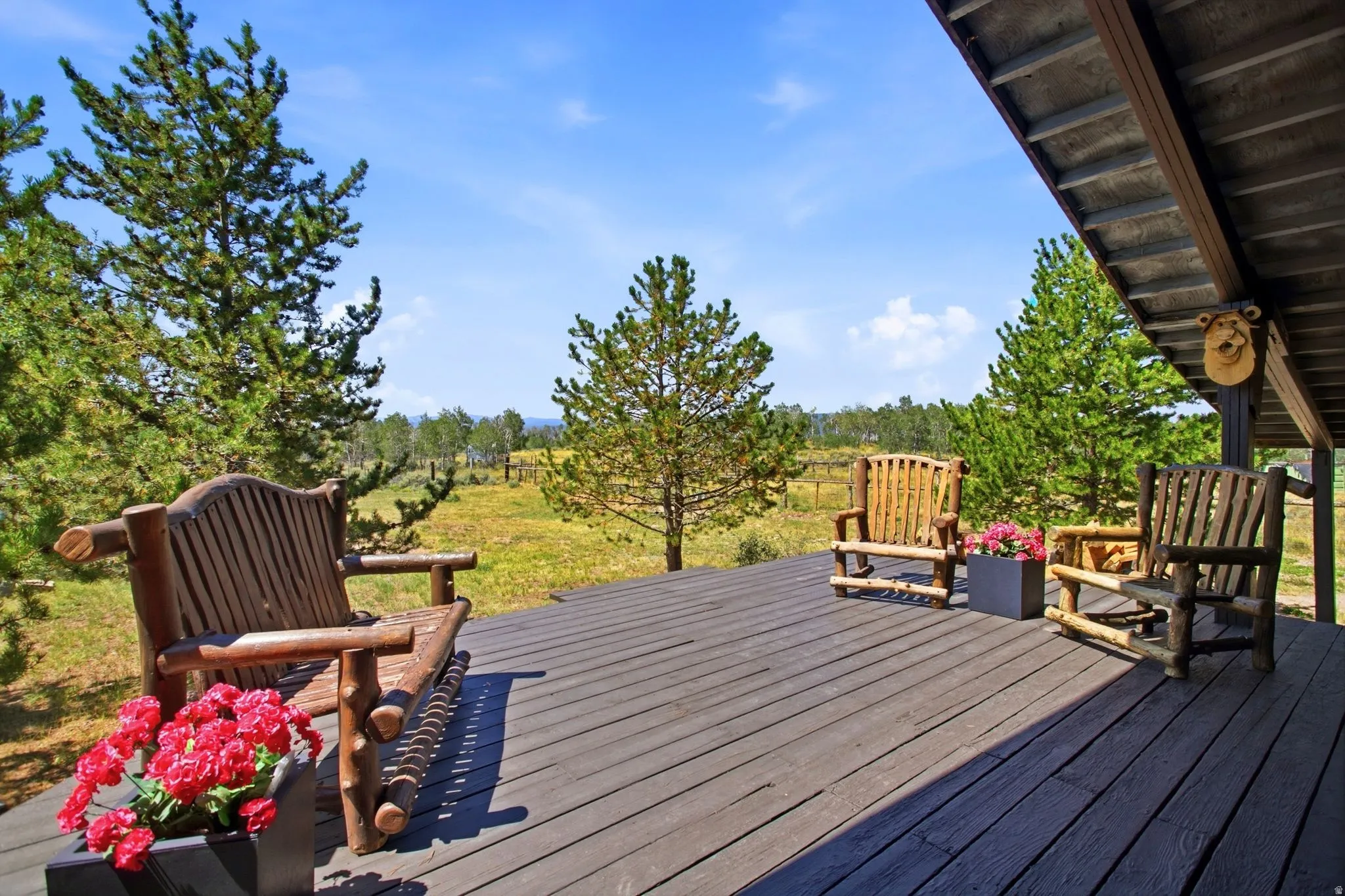 Expansive outdoor deck with a durable composite surface, featuring a covered area and a natural landscape backdrop
