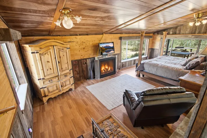 Wood-finish flooring, wood-paneled walls, and a wood-paneled ceiling create a cohesive interior