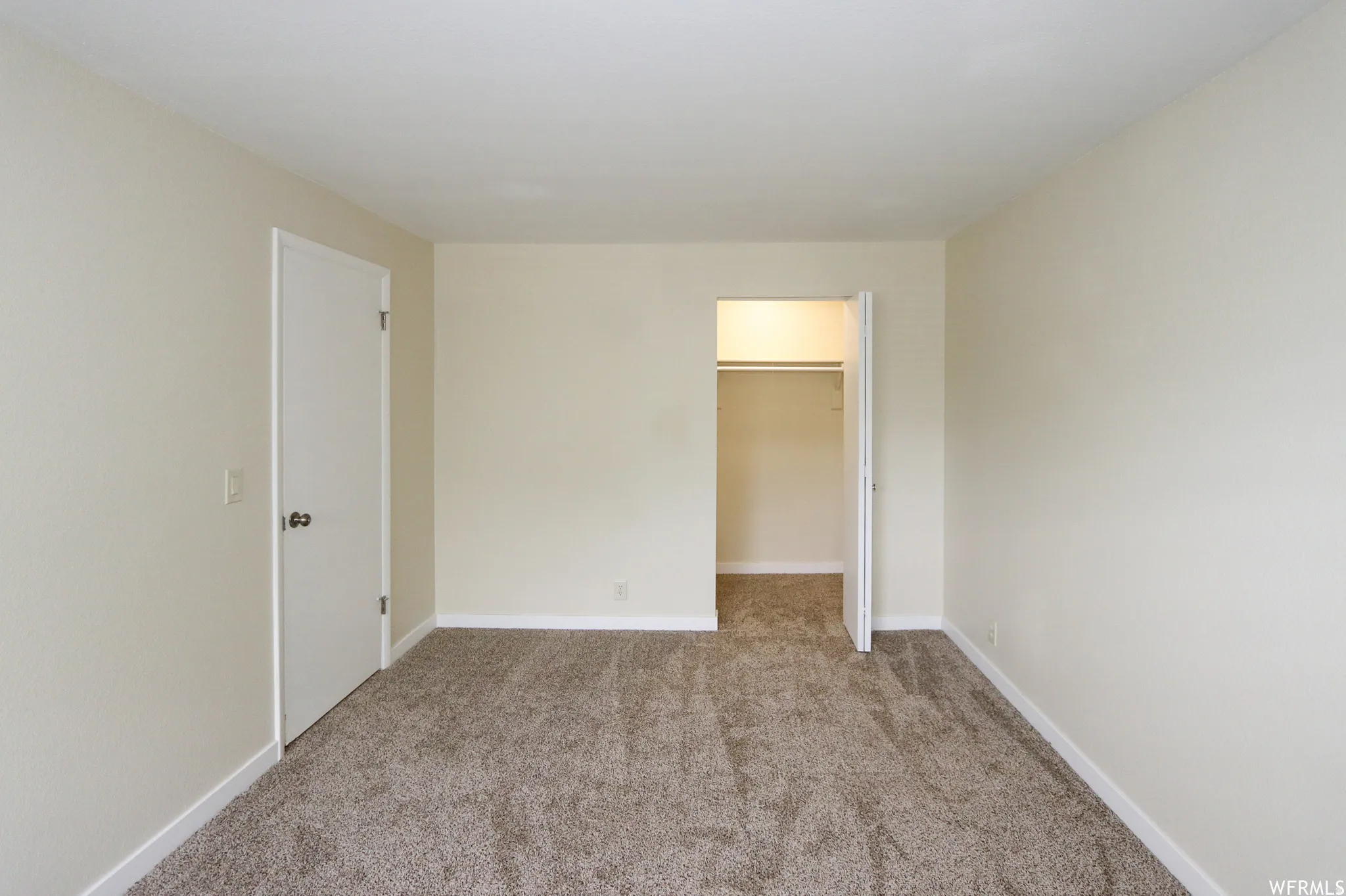 Neutral-toned walls complement the textured carpeting