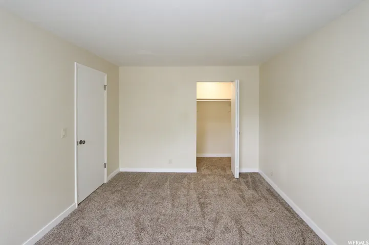 Neutral-toned walls complement the textured carpeting