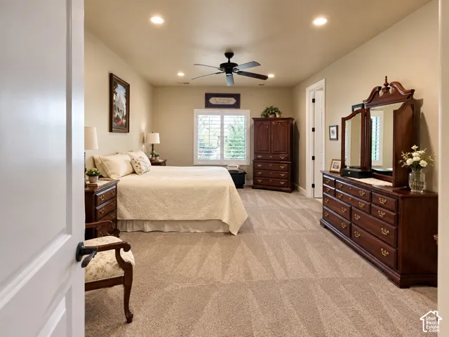 Primary suite. Recessed lighting, ceiling fan, neutral carpet flooring, white interior doors, and window with white shutters