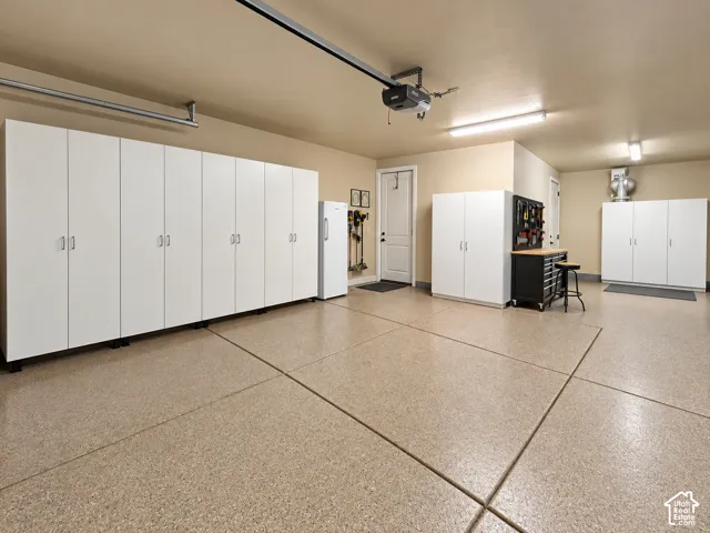 Epoxy-coated flooring, extensive built-in cabinetry, overhead fluorescent lighting, and a garage door opener system. More storage cabinets. Extra deep section for workbench or toy storage.