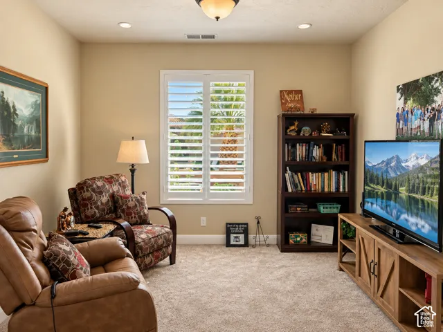 Carpeted bedroom/den featuring recessed lighting, a ceiling-mounted light fixture, and a window with white plantation shutters