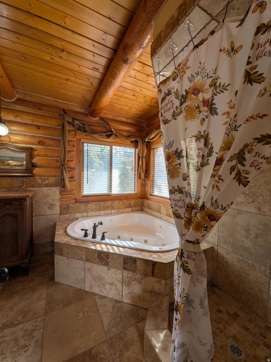 Corner jetted tub with tile surround, wood-paneled walls, and a wood-planked vaulted ceiling