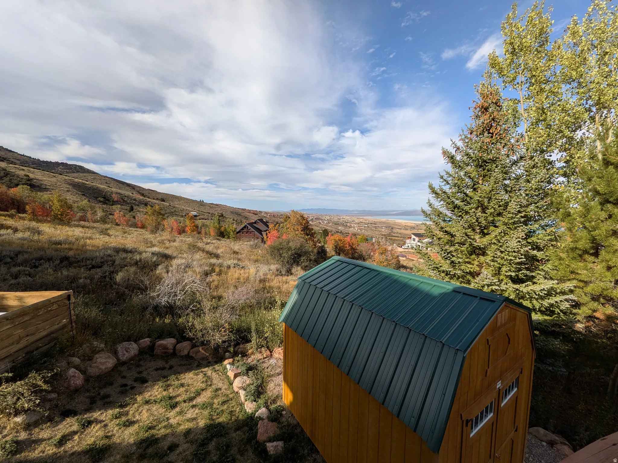 Detached wooden shed with a green metal roof