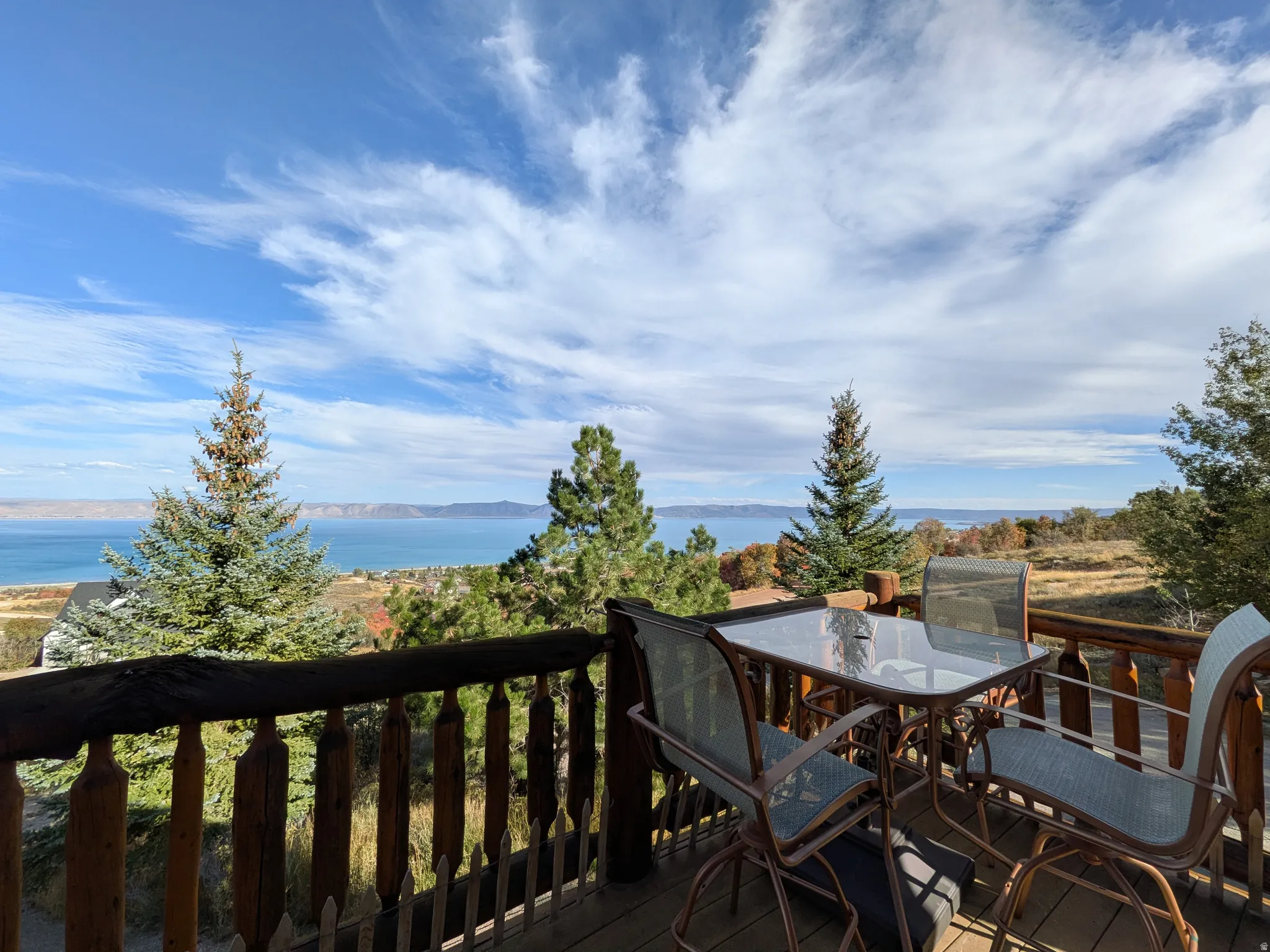 Expansive outdoor deck with a wooden railing and views of Bear Lake.