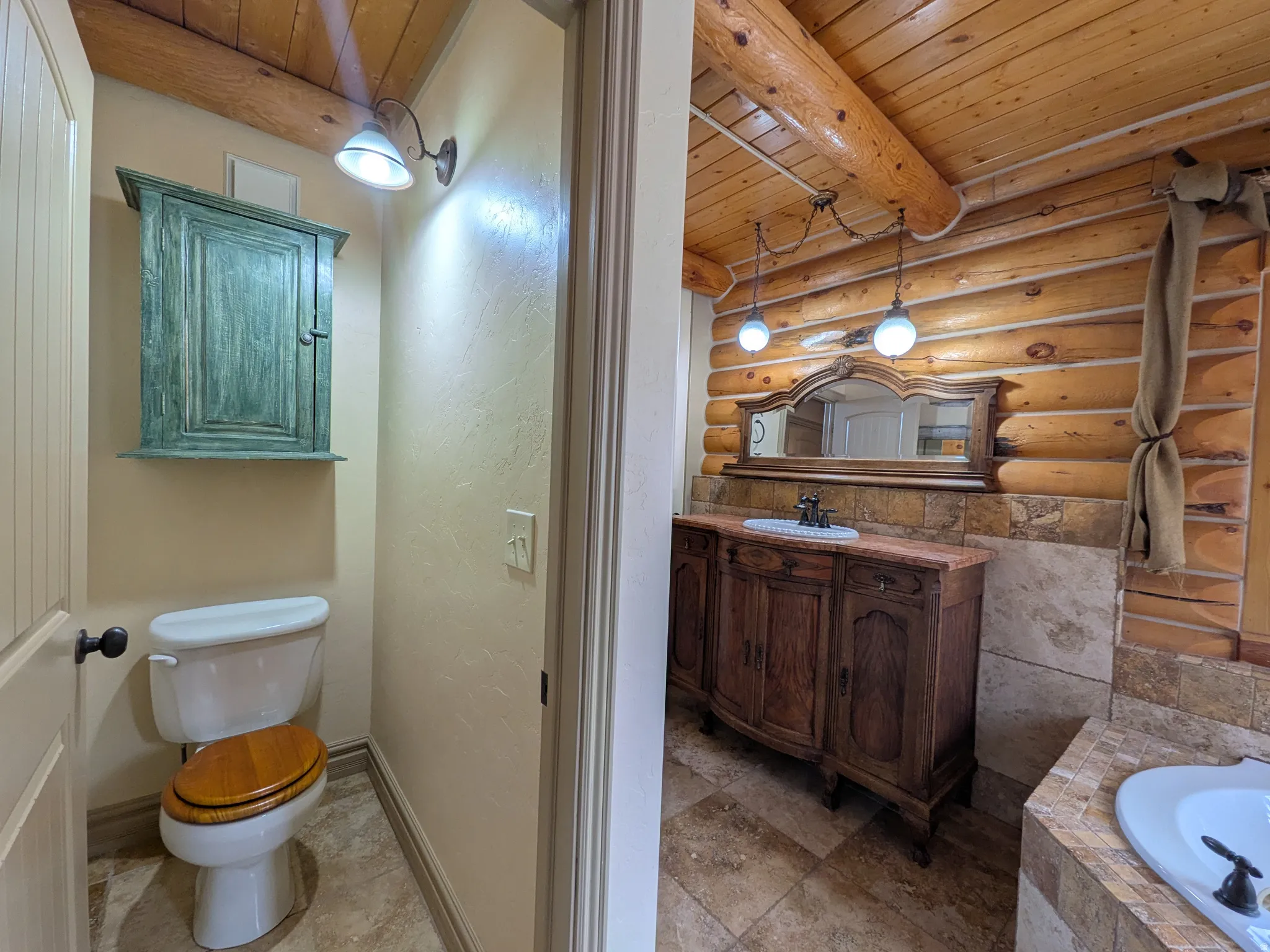 Log-cabin aesthetic with exposed ceiling beams and log wall paneling