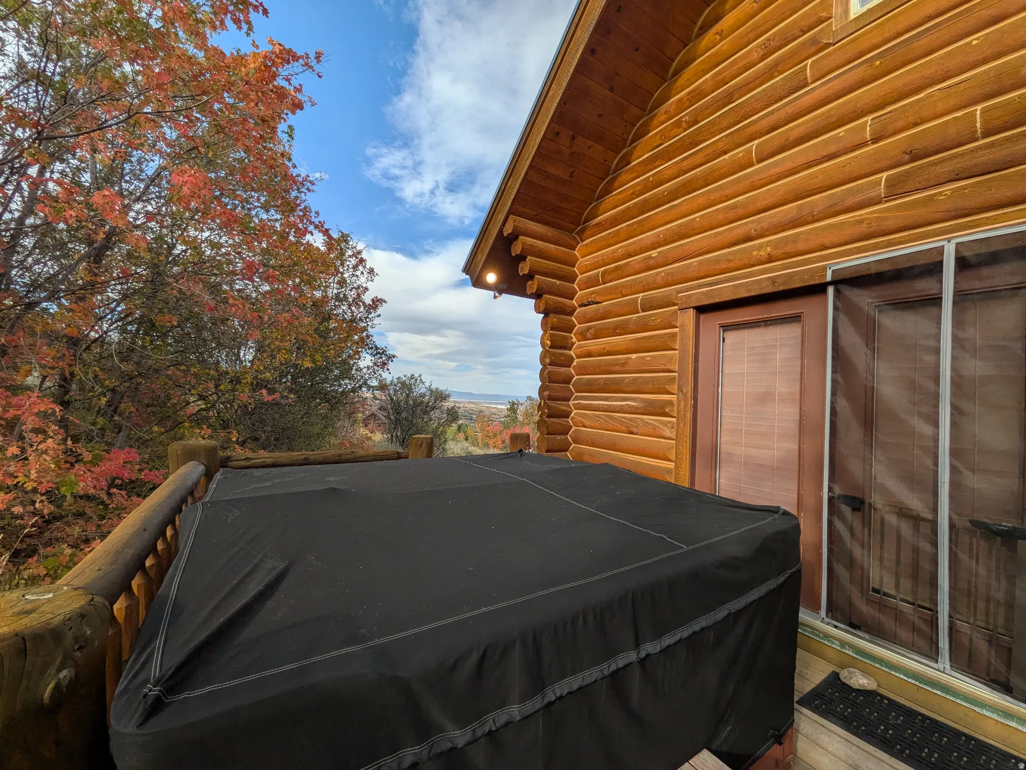 Deck off of the Mater Bedroom with natural wood siding, wood railing, and a covered outdoor spa