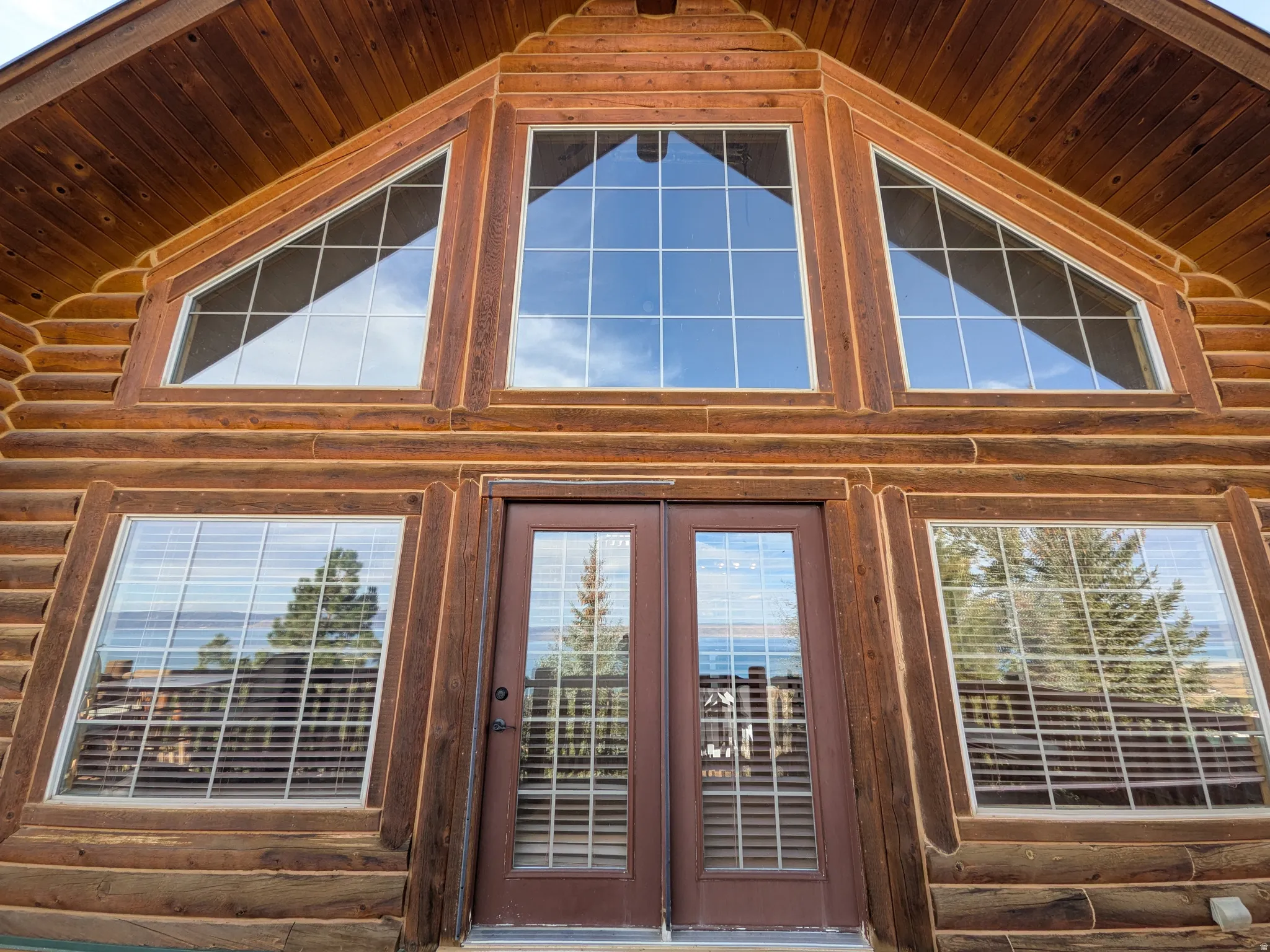 Log exterior with multiple large windows and a central double-door entry