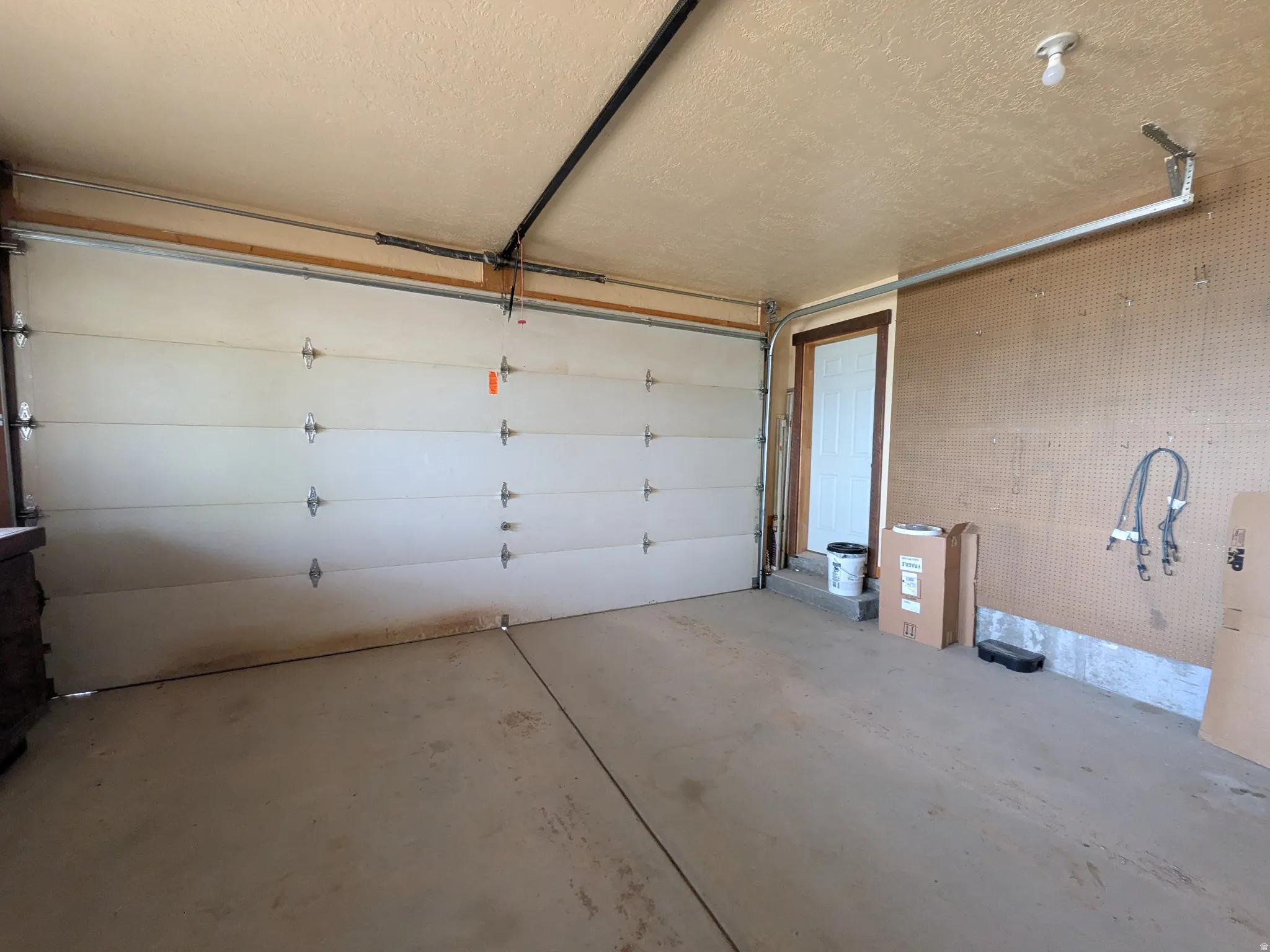 Concrete flooring and a white sectional garage door