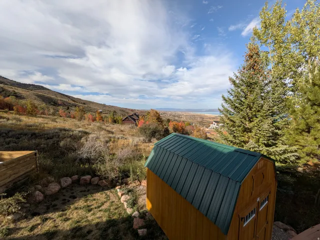 Detached wooden shed with a green metal roof