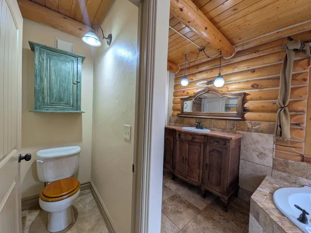 Log-cabin aesthetic with exposed ceiling beams and log wall paneling