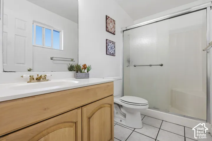 Wood-finish vanity with white countertop, integrated sink, and brass-tone faucet