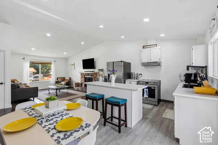 Open-concept living space featuring a vaulted ceiling and recessed lighting