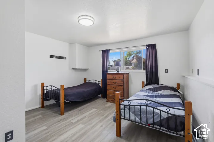 Wood-finish flooring, white walls, and a window with a white frame