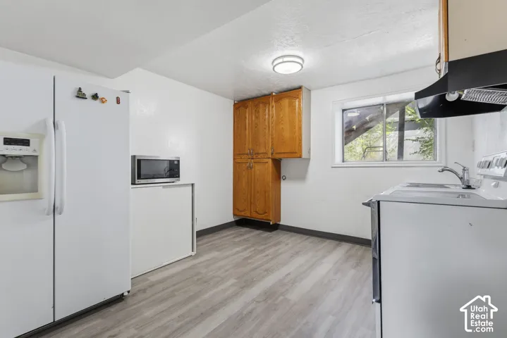 Kitchen featuring wood-finish flooring, a window, and built-in cabinetry
