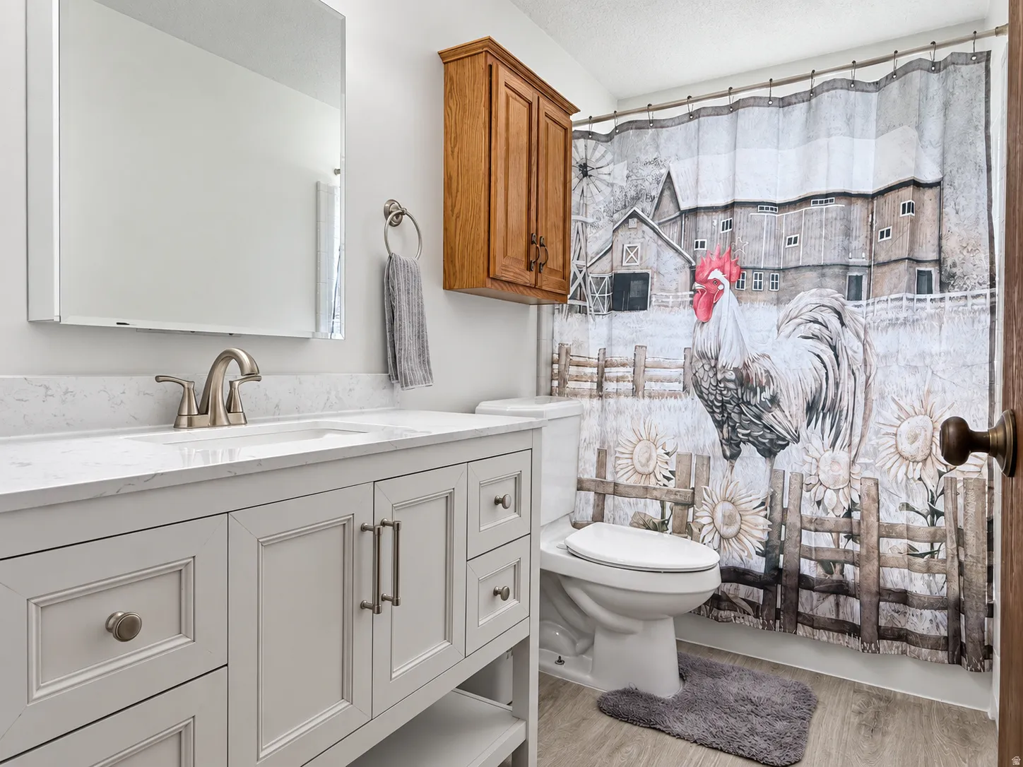 White vanity with inset panel doors and drawers, brushed nickel hardware, and a white countertop