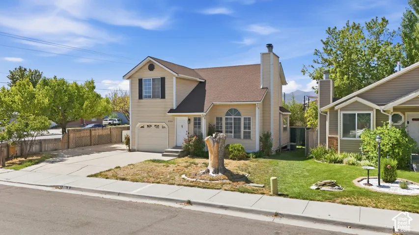 Two-story residence featuring a single-car garage and a paved driveway