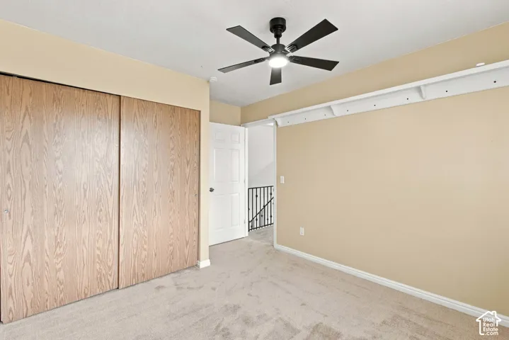 Wall-to-wall carpeting, wood-finish closet doors, and ceiling fan with integrated lighting