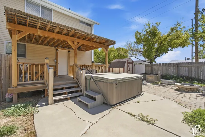 Covered wooden deck with slatted roofing, wood railings, and stairs