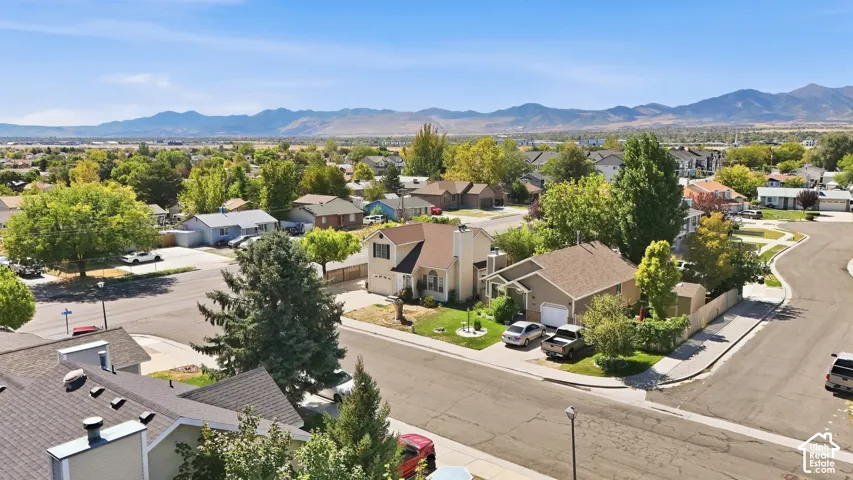 Residential neighborhood featuring mature trees and mountain scenery