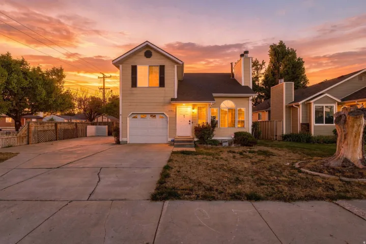 Two-story residence featuring a single-car garage and an expansive concrete driveway