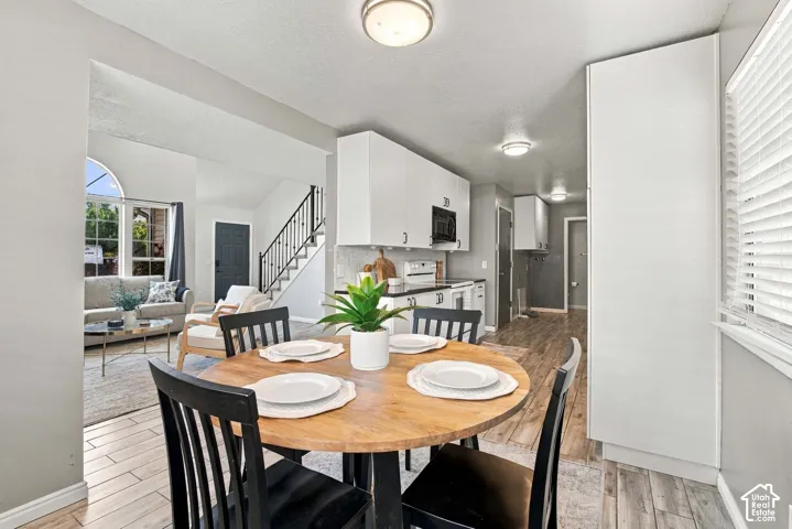 Open concept dining area featuring a wood-finish round table and black chairs