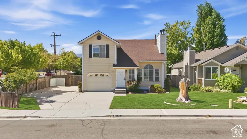 Two-story residence with a light-colored exterior and dark roof