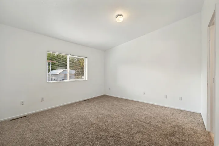 Neutral wall finishes with a ceiling-mounted light fixture and soft carpet flooring