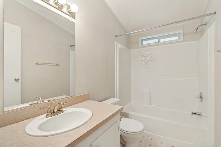 Vanity with an integrated sink, brushed nickel faucet, and mirror