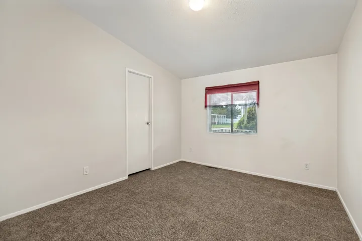 Neutral wall finishes, recessed window, and brown carpet flooring