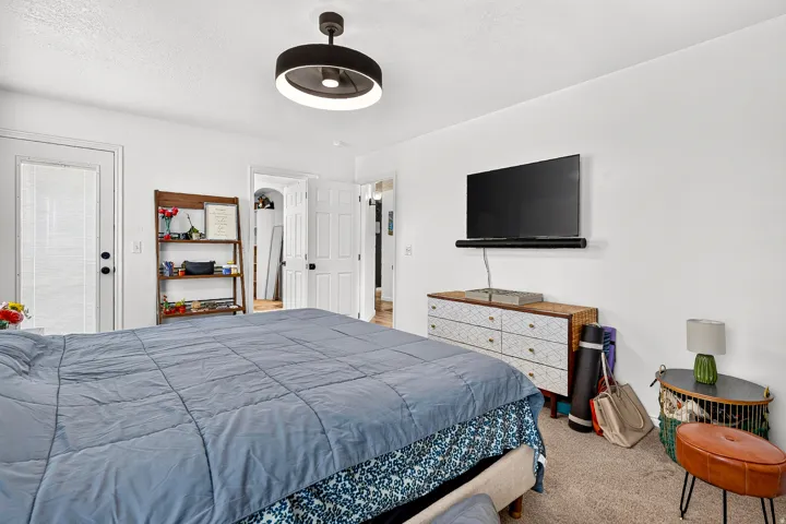 White walls, neutral carpet, and a modern flush-mount light fixture