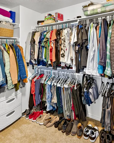 Customizable closet system with multiple hanging rods, integrated shelving, and built-in drawers