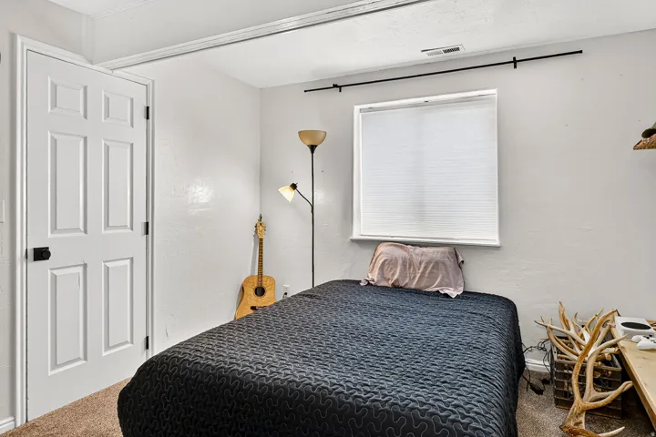 Recessed lighting, window with blinds, paneled door with dark hardware, and carpet flooring