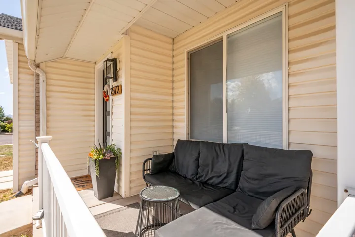 Covered entry porch featuring horizontal siding and a sliding window