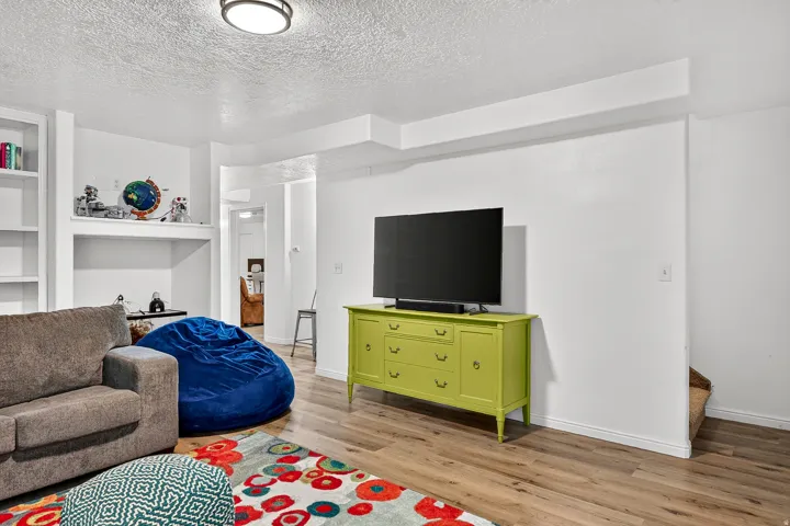 Recessed lighting, wood-finish flooring, built-in shelving, and painted white walls