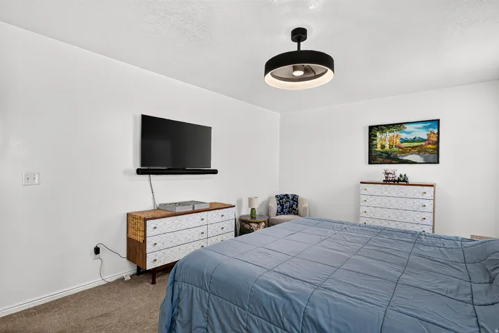 Wall-mounted television with soundbar, modern ceiling light fixture, and neutral wall color