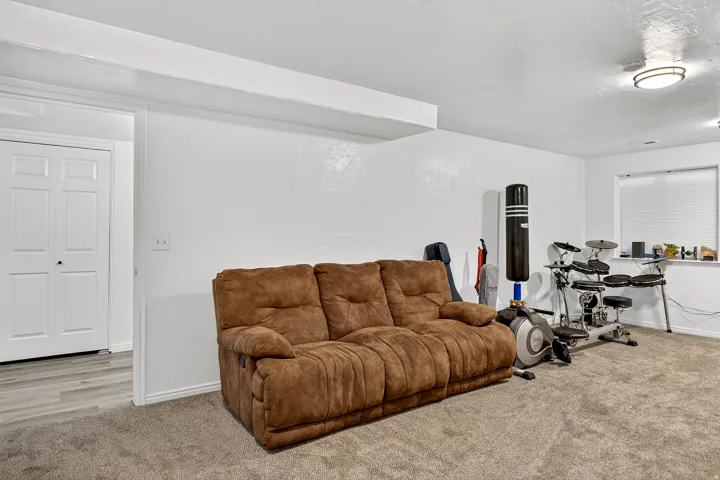 Recessed window, ceiling-mounted light fixture, white walls, carpeted flooring, and a two-panel closet door