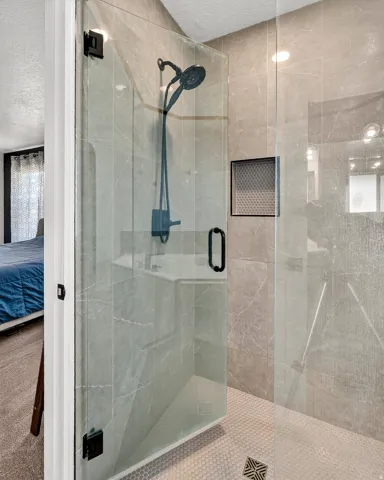 Glass-enclosed shower with matte black hardware