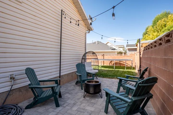 Paved patio area, string lighting, and exterior siding